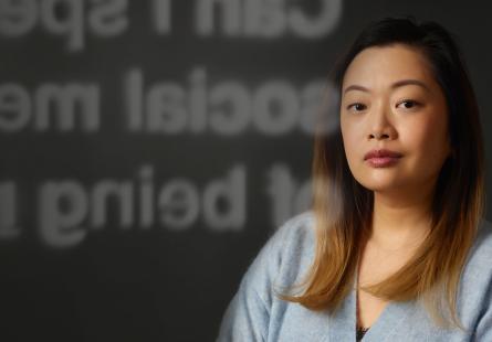 Young Asian woman looking to camera with campaign branding