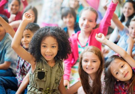Young children gather in a classroom environment