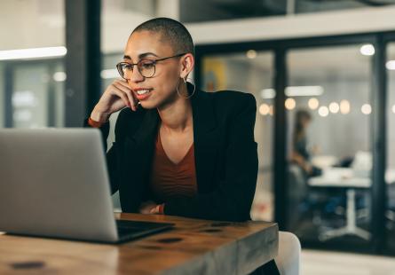 Young businessperson sits at their laptop computer