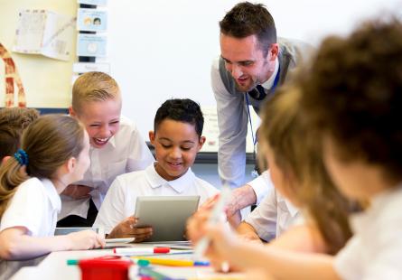 A teacher speaks to students in a primary school classroom
