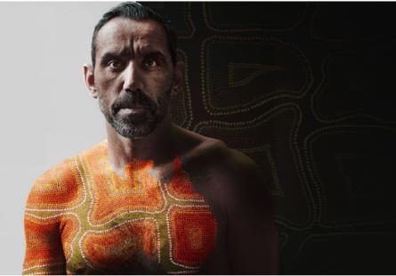 Depicts Adam Goodes standing facing the camera