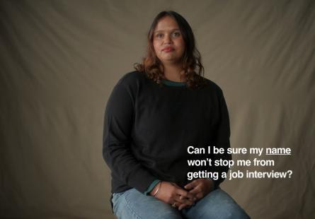 First Nations woman in chair looking to camera, with text "Can i be sure my name won't stop me from getting a job interview?"