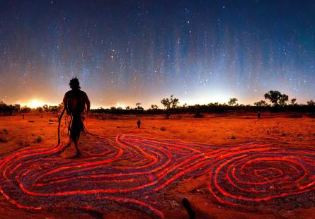 Silhouette walking on red dirt at dusk