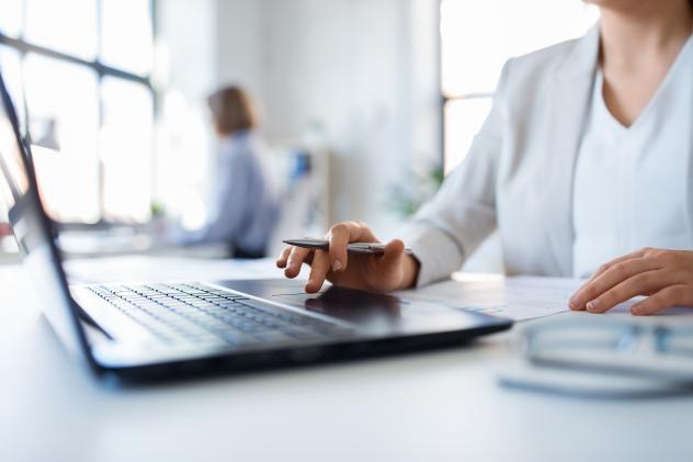 business and people concept - businesswoman with laptop computer and papers working at office